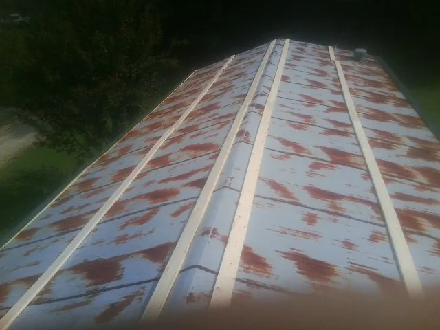 Rusted metal roof panels with new wood purlins before replacement — Storm Damage Roof Repair in Coatesville by Roofing Brothers