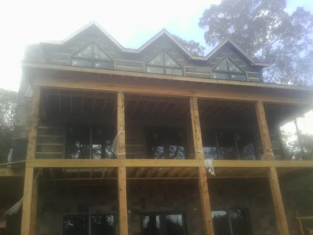 Dormers and porch framing on a large log home under construction — Roof Coating work by our crew in Coatesville